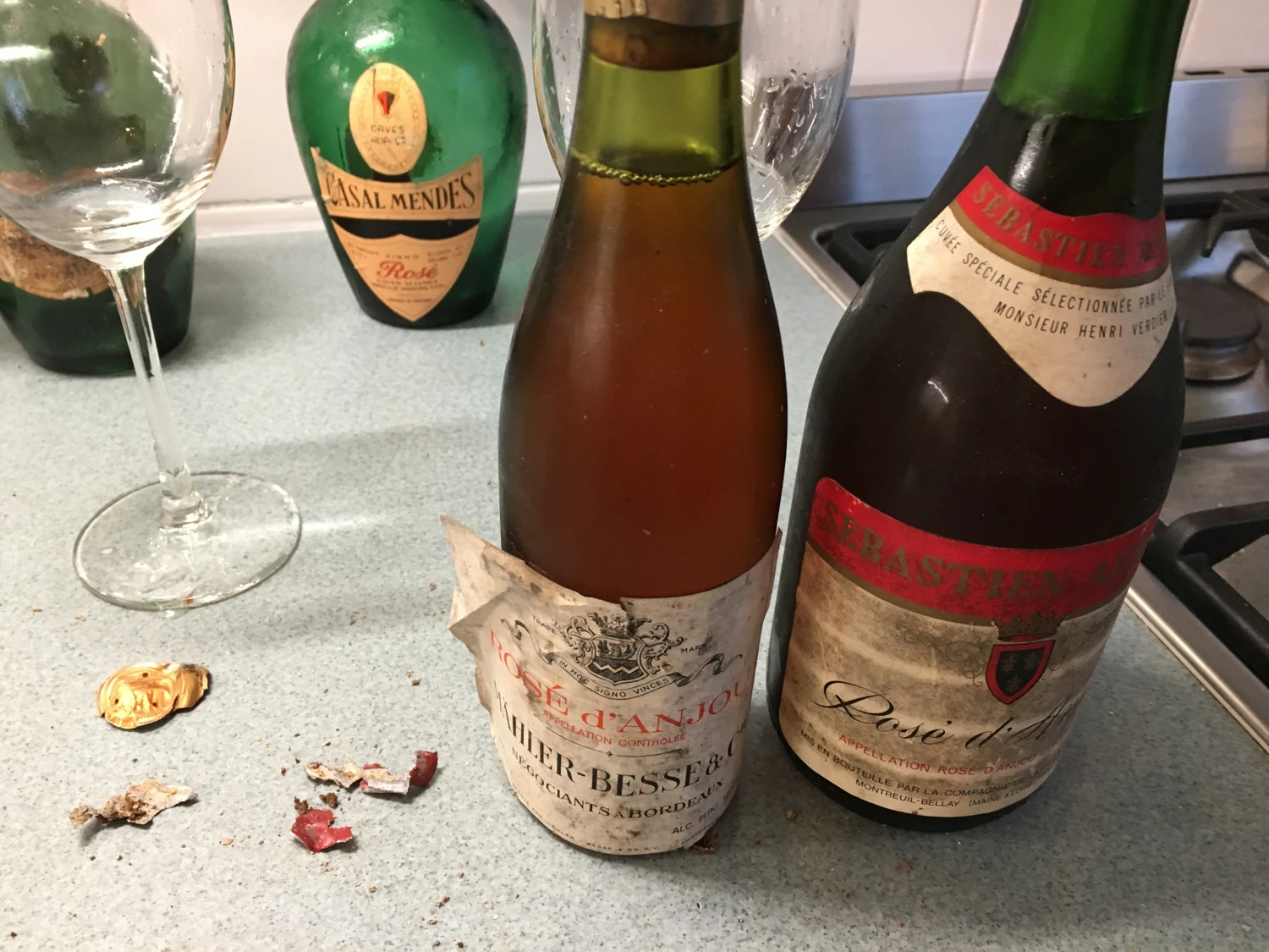 Oude roséflessen met verkleurde wijn en een verbrokkelde kurk.